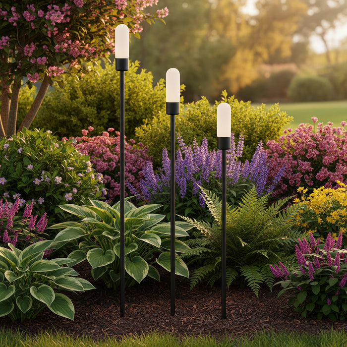 black landscape spike light installed in a garden border