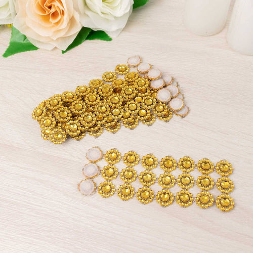 Gold decorative embellishments arranged on a light wood surface.