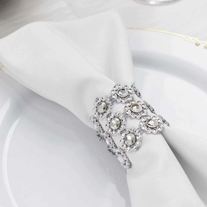 Elegant silver napkin ring adorned with crystals on a white napkin.