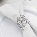Elegant silver napkin ring adorned with crystals on a white napkin.