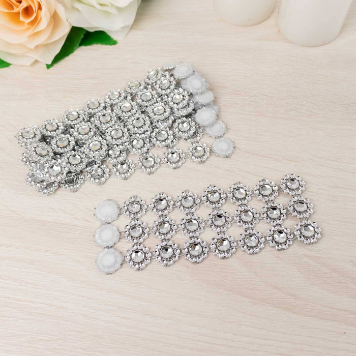 Silver rhinestone embellishments on a light wooden surface.