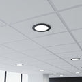 black low profile downlight installed into a suspended ceiling in an office