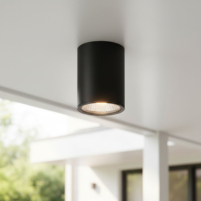 black outdoor surface mounted downlight fitted on an outdoor ceiling