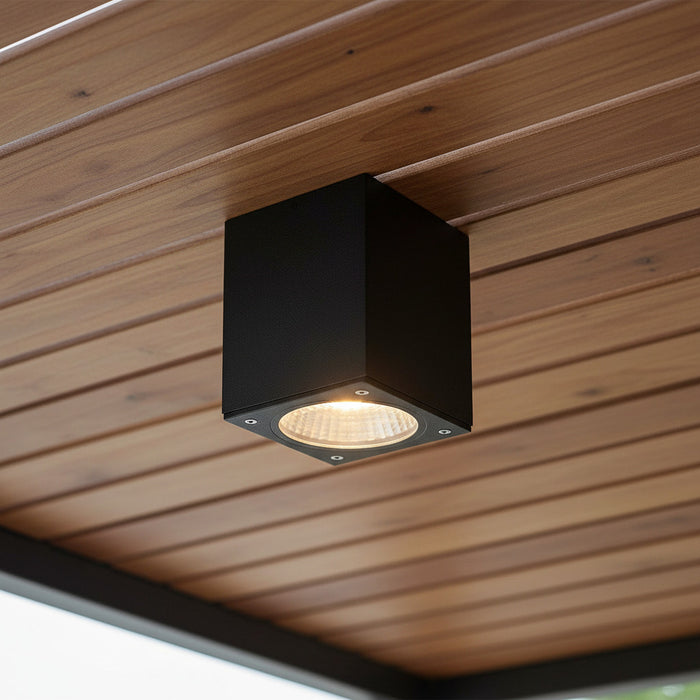 black outdoor soffit downlight mounted on a wooden exterior ceiling