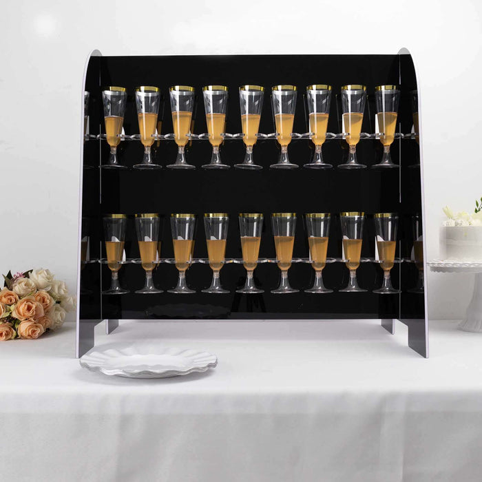 Elegant display of champagne flutes filled with orange juice on a sleek black stand.