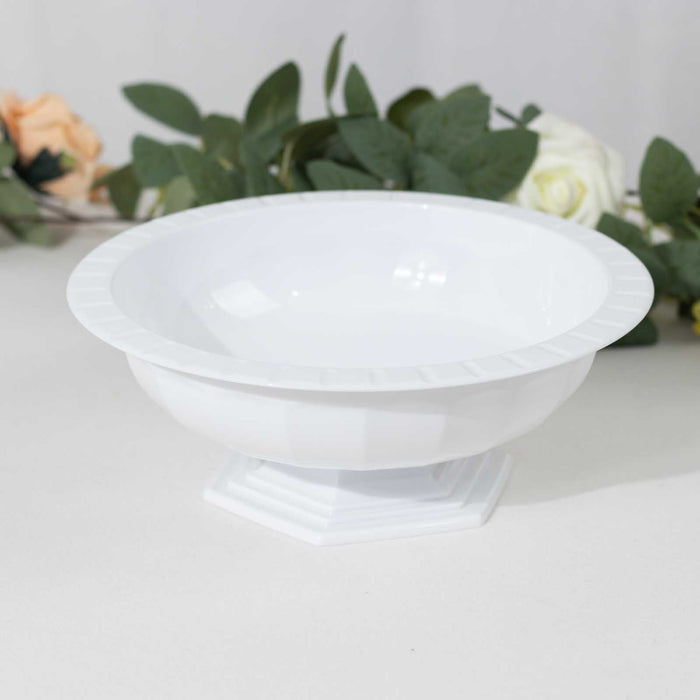 White decorative bowl on a pedestal against a plain backdrop.