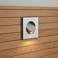 silver recessed wall or headboard reading lamp fitted into a modern wooden headboard in a bedroom