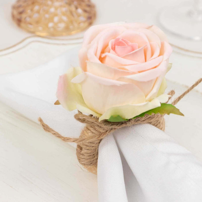 Rose napkin ring decoration with twine on a white table setting.