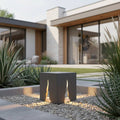 Grey contemporary bollard light set in the garden of a modern home
