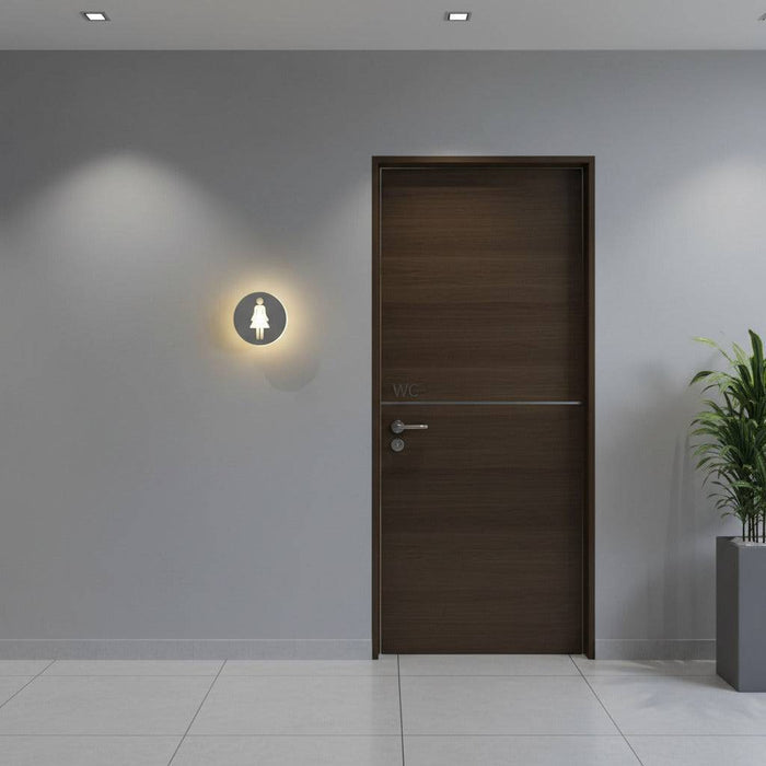 illuminated ladies toilet sign mounted on the wall next to the entrance of a ladies wc