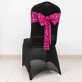 Black chair cover with fuchsia bow, perfect for events and celebrations.