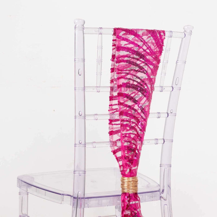 Pink sequined chair sash draped on a clear chiavari chair.