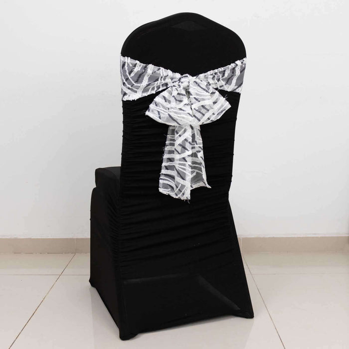 Black chair cover with white decorative bow on a plain backdrop.
