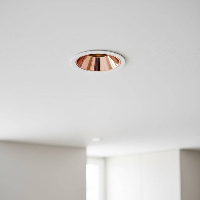 rose gold downlight mounted in the white ceiling of a modern house
