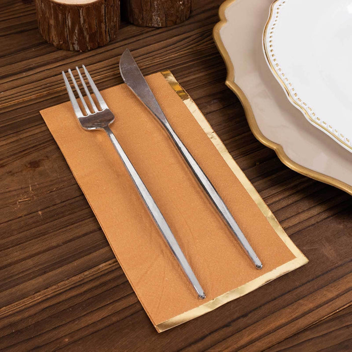 Elegant silver fork and knife on a brown napkin with decorative plate in background.