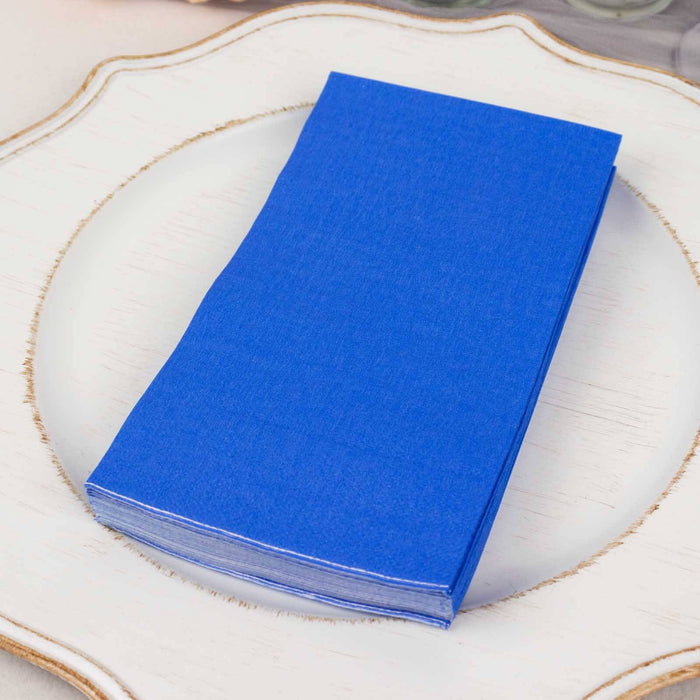 Blue napkins stacked on a decorative plate.