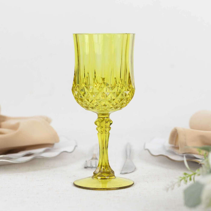 Yellow crystal goblet with intricate design on a plain background