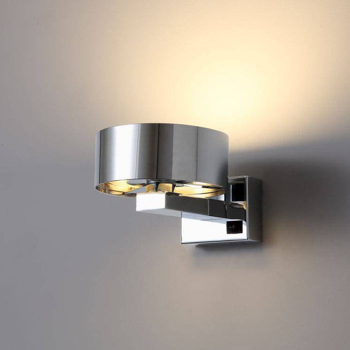 Chrome bed side wall reading light mounted on a white wall