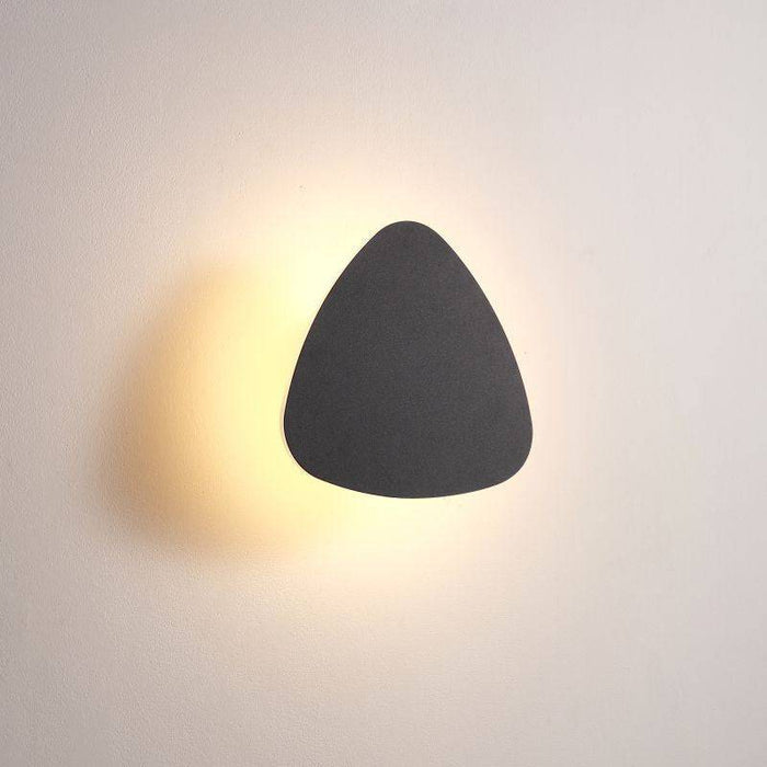 black bathroom sconce light shown fitted on a white wall