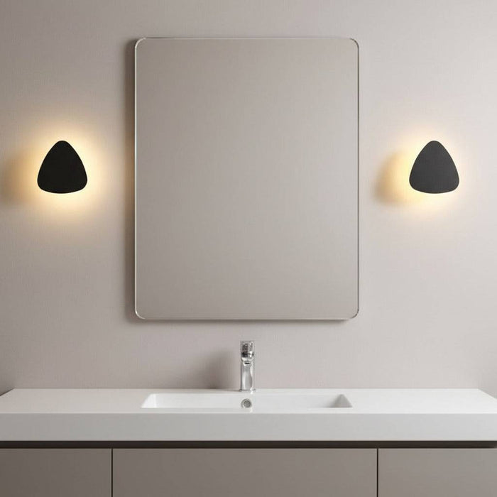 black bathroom sconce light mounted either side of the mirror above a bathroom vanity