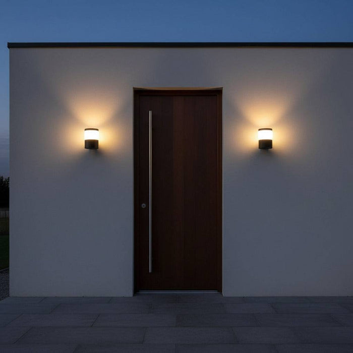 black outside wall lantern mounted either side of a wooden front entrance door