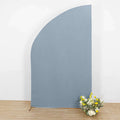 Blue fabric backdrop with floral arrangement in front.