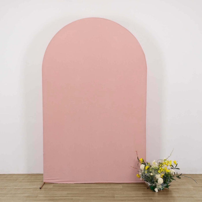 Pink arch backdrop with floral arrangement in front.