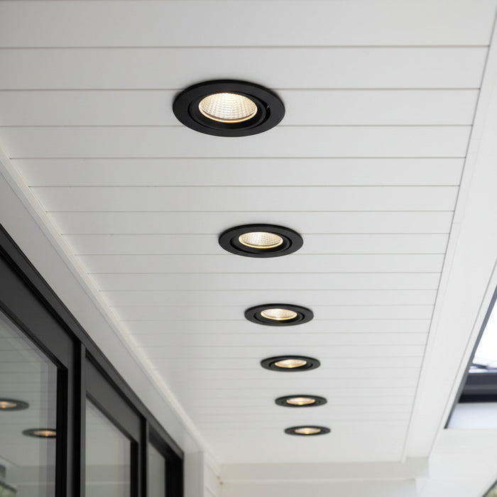 black outside downlight mounted along the soffit of a modern home