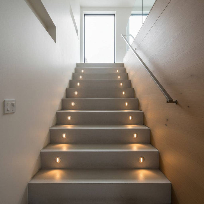 silver recessed step light installed on a modern stair case