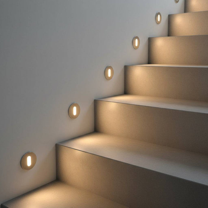 silver recessed step light mounted on the wall next to steps