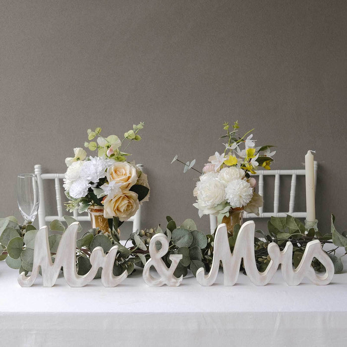 Mr & Mrs decorative letters with floral arrangements on a table setting.