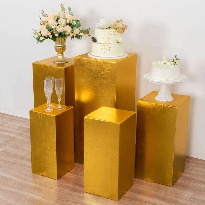 Gold pedestal displays showcasing cakes and floral arrangements.