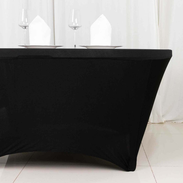 Black table cover with white plates and napkins set for dining.